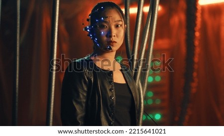 Cyberpunk girl in a black leather jacket looks fiercely at the camera. Asian girl with one-eyed glasses and headset trapped. Black thick rods hanging to prevent her from escaping.