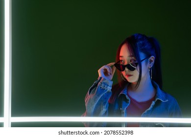 Cyberpunk portrait. Millennial nightlife. Advertising background. Content promotion. Fashionable gorgeous woman in neon LED light isolated on dark copy space.