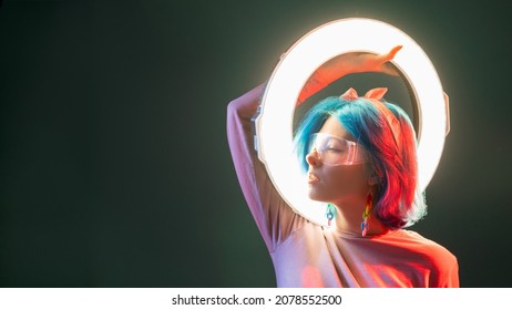 Cyberpunk woman. Synth wave style. Neon light sci-fi. Profile of stylish futuristic model with LED ring flash lamp in red glow isolated on dark copy space background banner.