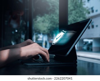 Cybersecure, internet network security technology, privacy data protection concepts. Safety shield icon hologram appears while person work with digital tablet computer with free wifi in coffee shop. - Powered by Shutterstock