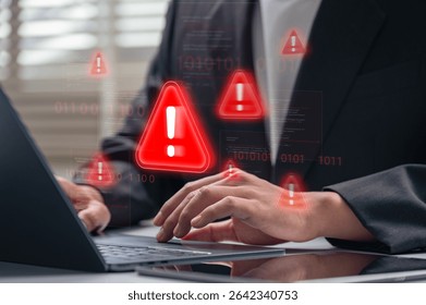 Cybersecurity alert warning displayed on laptop screen while businessman types during work. corporate hacking threat, cyberattack, data breach and malware threat in professional setting,