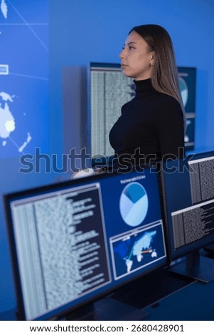 Cybersecurity analyst reviewing digital data dashboards for threat detection and analysis