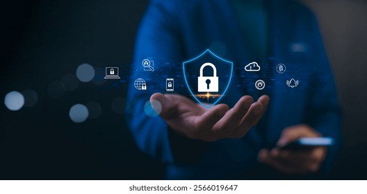 Cybersecurity concept, hand holds a glowing shield icon with a padlock, symbolizing cybersecurity and data protection. Digital icons for devices and security float around. Concept online safety.