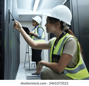 Cybersecurity, database and server room with engineer women at work to maintain computer network. Checklist, documents and repair with technician people working to install firewall on mainframe