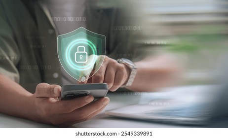 Cybersecurity and digital data protection, Close-up of a person using a smartphone with a digital shield and lock icon, representing mobile data protection and secure authentication.