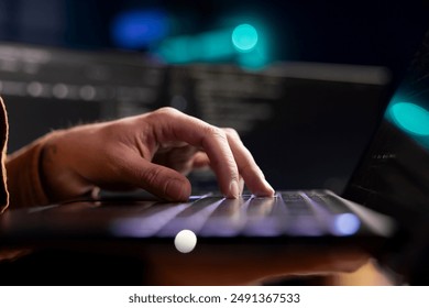 Cybersecurity expert using laptop to look for company security vulnerabilities and prevent malware infections. Developer installing fortified code on notebook to prevent cyberattacks, close up shot - Powered by Shutterstock