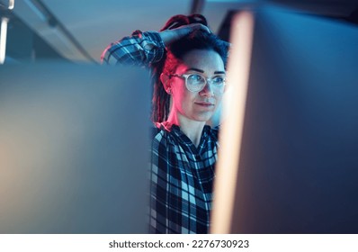 Cybersecurity, malware and woman hacker working on a computer in the basement at night for phishing. Database, password and ransomware with a female coder hacking a digital transformation network