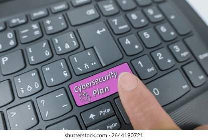 Cybersecurity plan key on a gray keyboard. Finger pressing key