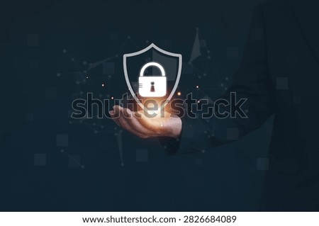 Cybersecurity protection concept featuring glowing shield and padlock in business professional's hand, symbolizing data security, network defense, privacy protection, digital risk management.