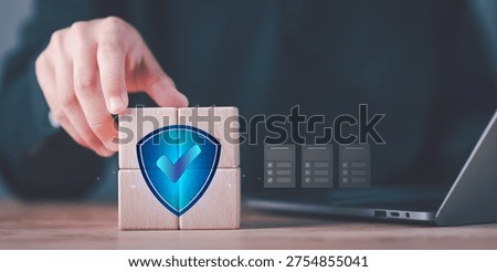 Cybersecurity specialist implementing data protection strategy with shield security icon on wooden blocks, ensuring compliance, risk management, privacy protection and secure digital infrastructure