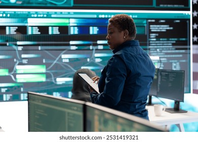 Cybersecurity specialists in a high tech office with the American flag, focusing on cyber intelligence and secure network operations. Works on information security and malware detection. - Powered by Shutterstock