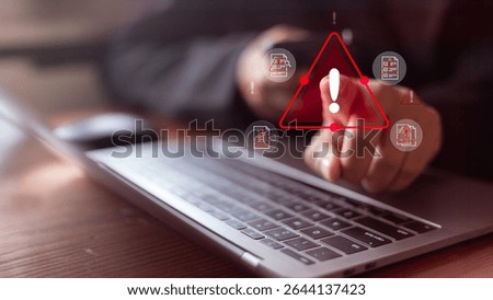 Cybersecurity warning concept with user pointing at a red alert icon on a laptop. Data breach risk, malicious files, system vulnerability, document security threat, and digital information leaks.