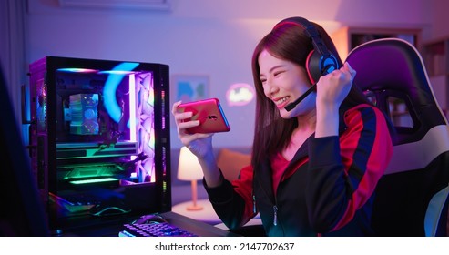 cybersport gamer earns cryptocurrency from game-fi or NFT games through mobile phone with fist gesture at home - Shutterstock ID 2147702637