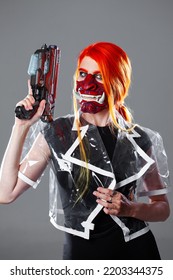 Cyborg Mercenary In Asian Demon Mask, Young Woman With Bright Orange Hair With A Gun In Her Hands, Futuristic Cyber Punk Style