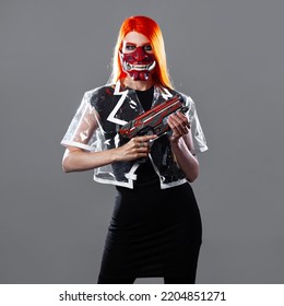 Cyborg Mercenary In Asian Demon Mask, Young Woman With Bright Orange Hair With A Gun In Her Hands, Futuristic Cyber Punk Style