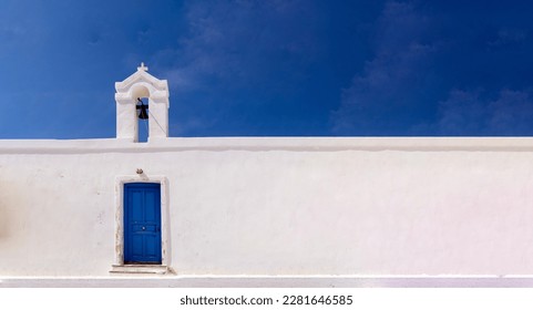 Cyclades, Greece. Small white church wall and belfry against blue sky, sunny day. Copy space - Shutterstock ID 2281646585