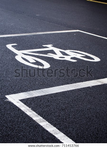 Cycle logo at a London traffic light with\
bitumen background