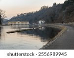 Cycle pedestrian path along one of the canals that originate from the Ticino river.  Canale Villoresi (Villoresi canal) and the the Panperduto dam (visible in the background), Somma Lombardo, Italy 