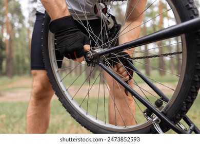 Cycling, adventure trail and bike repair, man fix wheel in forest. Close up of mans hands repairing a bike. - Powered by Shutterstock