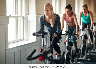 Cycling class, fitness instructor and women riding exercise bikes for cardio workout and collaboration. Smile, female people and health for bicycle training with coach for support and advice - Powered by Shutterstock