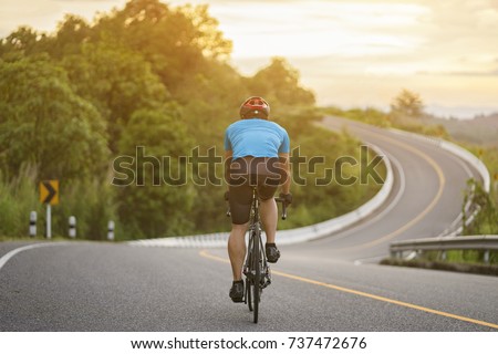 Cycling competition,cyclist athletes riding a race at high speed on mountain road, Sportsmen bikes in the morning,back view,vintage color,selective focus, sports concept,copy space