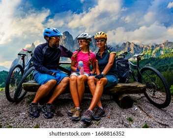 Cycling Family Outdoor Adventure In Dolomites Mountains Landscape. Father, Mother And Daughter Cycling MTB Enduro Trail. Outdoor Sport Activity.