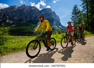 Cycling family riding on bikes in Dolomites mountains landscape. Couple cycling MTB enduro trail track. Outdoor sport activity. - Powered by Shutterstock