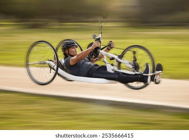 Cycling, fitness and fast with man and handcycle in nature for training, sports and challenge. Exercise, workout and motion blur with person with a disability in park for cardio and health on road - Powered by Shutterstock