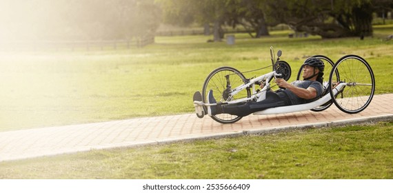 Cycling, fitness and space with man and handcycle in nature for training, sports contest and challenge. Exercise, workout and banner with person with a disability in park for cardio and health mockup - Powered by Shutterstock