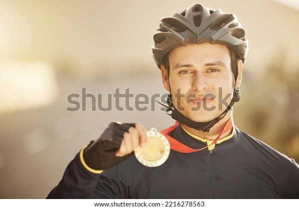 Cycling, helmet and medal with a sports man after a\
race as a winner, champion or medalist outside. Motivation,\
celebration and win with a young male athlete proud of reaching a\
target or goal