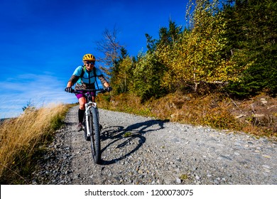 Cycling, mountain bikeing woman on cycle trail in autumn forest. Mountain biking in autumn landscape forest. Woman cycling MTB flow uphill trail. - Shutterstock ID 1200073075