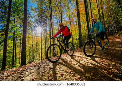 Cycling, mountain bikeing woman on cycle trail in autumn forest. Mountain biking in autumn landscape forest. Couple cycling MTB flow uphill trail. - Shutterstock ID 1648306381