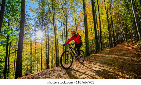 Cycling, mountain biking woman on cycle trail in autumn forest. Mountain biking in autumn landscape forest. Woman cycling MTB flow uphill trail. - Shutterstock ID 1187667901