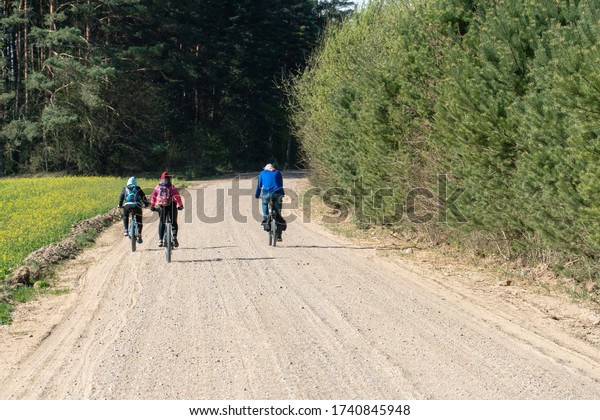 Cycling in nature. bike trip on a warm Sunny day\
on an empty dirt road. Road without cars along the forest. Weekend\
in nature with your\
family.