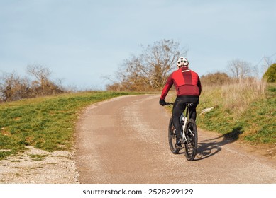 Cycling on a country road. Riding a bike. Cycling in winter. Walking in the countryside. Rural walk. Cycling alone. Protection on the bike - Powered by Shutterstock