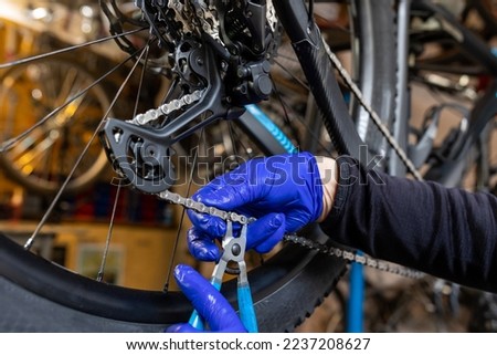 Cycling technician repairing and maintaining bike and gear shifter in workshop