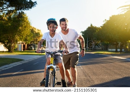 Cycling through his block. Shot of a young boy riding his bicycle through his neighbourhood.