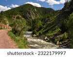 cycling trail, granite peaks and rapids on  in  the south platte river on a sunny  summer day  in  waterton canyon, littleton,  colorado