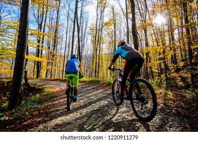 Cycling woman and man at Beskidy mountains autumn forest landscape. Couple riding MTB enduro track. Outdoor sport activity. - Shutterstock ID 1220911279