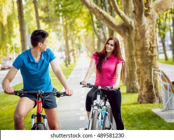 Cycling Young Couple. In The Park. Beautiful Bicycle Lane