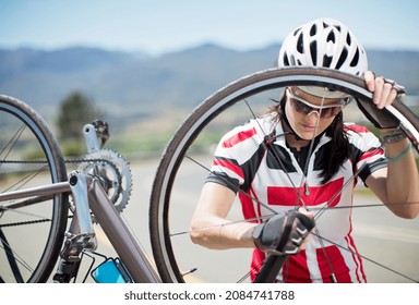 Cyclist adjusting tire on rural road - Powered by Shutterstock