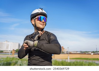 Cyclist Adjusts Smartwatch While Preparing to Ride on a Sunny Day in an Urban Park Setting - Powered by Shutterstock