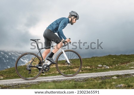 Cyclist athlete pedals uphill to an an alpine pass