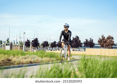 A cyclist in a black outfit rides through a green park on a sunny day, surrounded by nature and city life.

 - Powered by Shutterstock