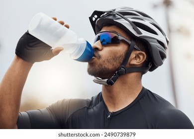 Cyclist, break and drinking water with bottle while cycling for fitness, health and french sports competition. Man, tired and hydration with clear liquid as athlete for race, performance and wellness - Powered by Shutterstock