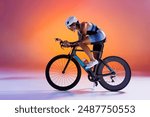 Cyclist in colorful sportswear and white helmet riding road bike against gradient orange and pink background in neon light. Concept of sport, competition, tournament, championship, speed, endurance