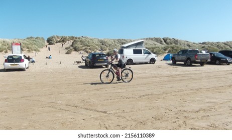 Cyclist Cycling On The Beach At Ainsdale With Bright Blue Sky And Copy Space, Ainsdale UK, 14-05-2022