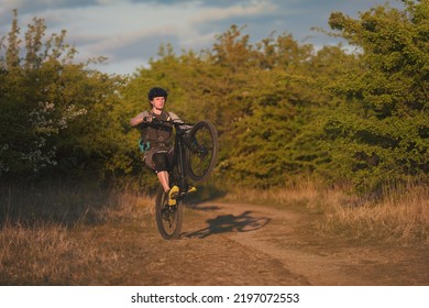 A Cyclist Doing A Wheelie Trick On A Mountain Bike On A Nature Trail.