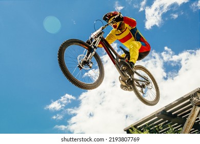 cyclist drops downhill in bokeh background blue sky