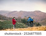 Cyclist is filming video, riding in nature and cameraman with a camera is capturing his adrenaline ride.